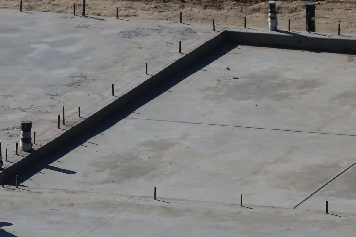 Losa de hormigón de una vivienda recién hecha, con las salidas de las tuberías y el borde de la cimentación